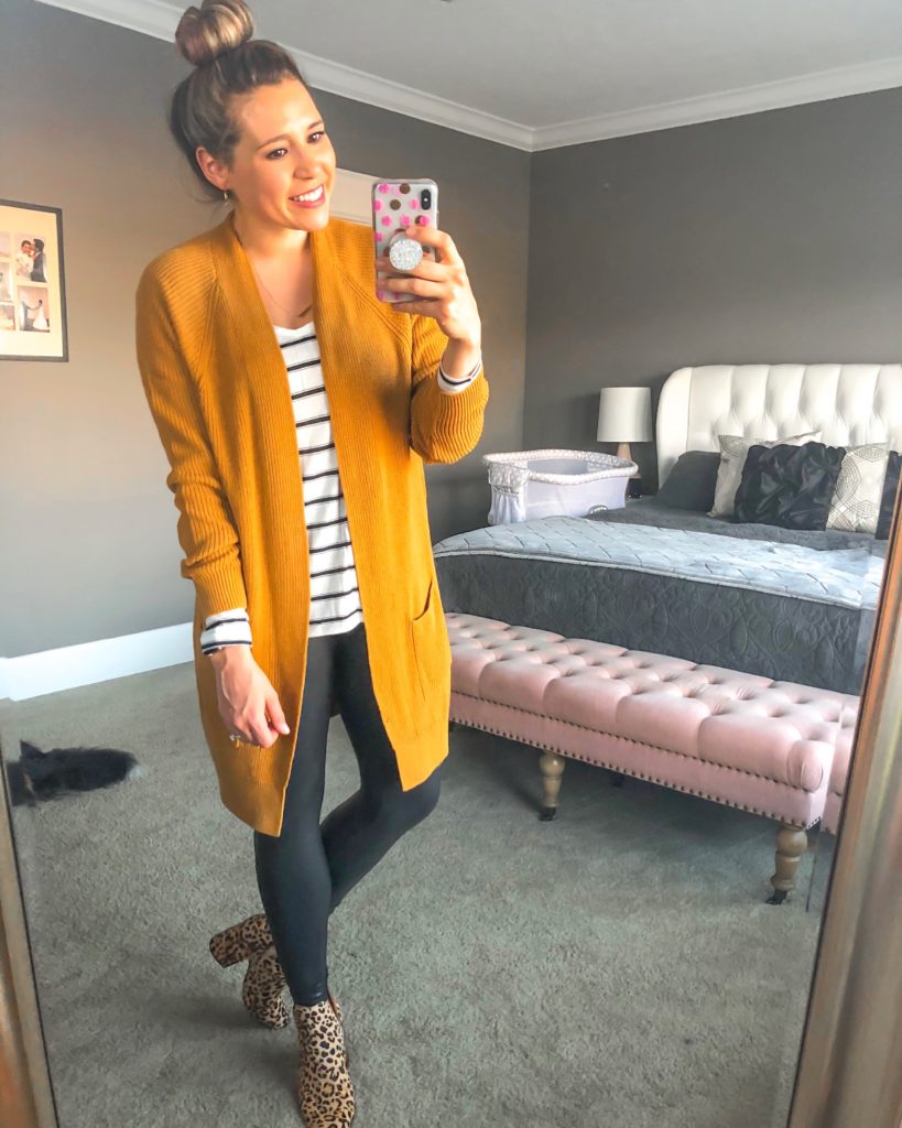 casual fall transition outfit inspiration- camel/mustard cardigan, white and black stripe long sleeve tee, black spanx faux leather leggings, calf hair leopard booties and top knot bun